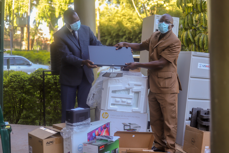 Geoffrey Mwedde, Chief of Party of the USAID/Uganda CWC Activity hands over equipment to Mr. Sam Mwanda, Chairperson of the National Wildlife Crime Coordination Task Force at Uganda Wildlife Authority.   Photo by Louisa Kiggwe/WCS